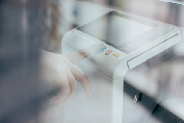 Step into the future of office technology with this dynamic stock photo, featuring a businesswoman's hand pressing the copy machine button in a modern office. The image captures the seamless blend of technology and business, symbolizing efficiency and progress. Ideal for conveying the futuristic aspects of office work, this photo is perfect for business-related promotions, technology publications, and social media content celebrating advancements in workplace automation, Touching the Future, Businesswoman, Copy machine, Modern office, Office Technology, Efficiency, Progress, Technology and business, Business-related promotions, Technology publications, Social media, Workplace automation advancements.