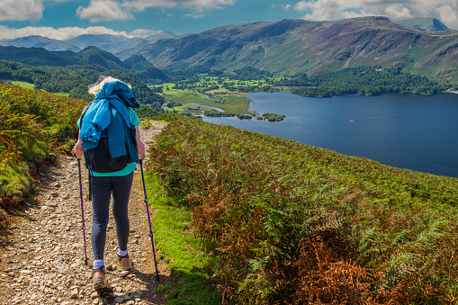 Senior female hiker hiking from Walla Crag, a viewpoint just south of Keswick overlooking Derwent Water in the Lake District of Cumbria, England.