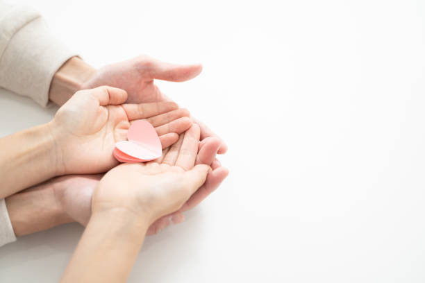 A couple holding a heart-shaped paper craft symbolizing their love