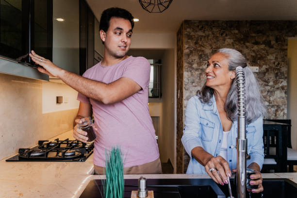 istock Mother and son talking and preparing coffee in the kitchen at home 1897324859