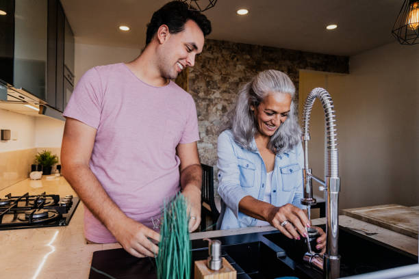 istock Mother and son talking and preparing coffee in the kitchen at home 1897324864