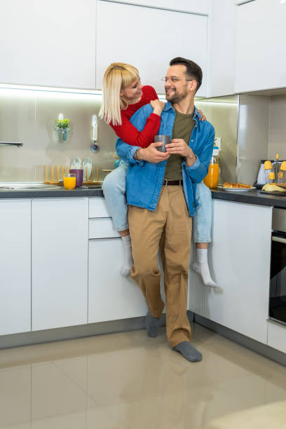 istock Young man and woman standing in kitchen and talking. 1897424657