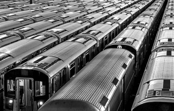 trains inside train yard (black and white photo) queens (mets willets point stop in corona flushing meadows queens) modern subway rail cars (7 line, commute, travel, commuter, metro) storage abstract