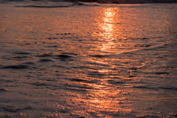 The sunrise reflected into the waves of the Atlantic Ocean off the coast of Avon By The Sea, New Jersey on the jersey shore