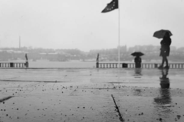istock Unrecognizable person standing with a umbrella at a flag pole 1897559368