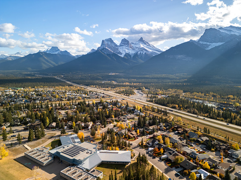 Canmore, Alberta, Canada. Aerial view of Trans-Canada Highway (Highway 1) in a autumn sunny day. The Three Sisters trio of peaks Canadian Rockies mountain range.