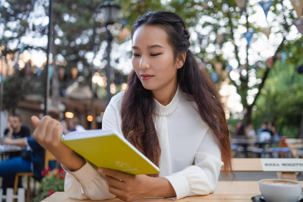 istock Asian Woman Reading Book in the Cafe 1897614624