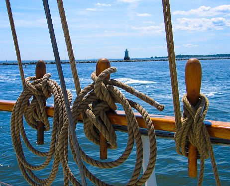 Gleaming in the sun, the mast, platform, stays and spars of an old sailing ship.