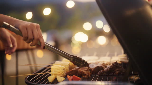 Woman preparing food outdoors in backyard with friends At the gathering party