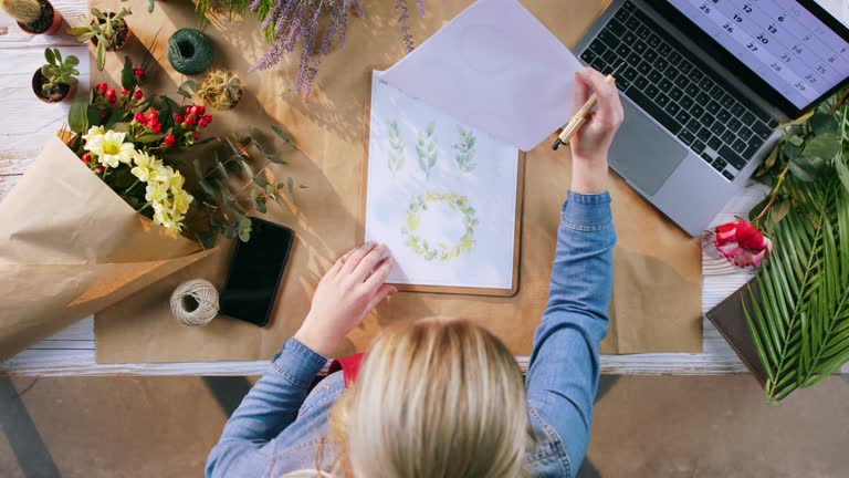 Top view of woman completing an order of flowers.