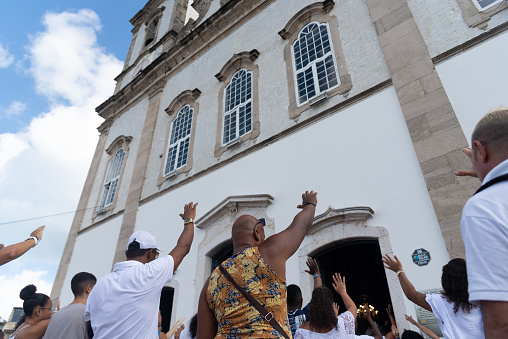 Salvador, Bahia, Brazil - December 29, 2023: Catholic faithful pray to Senhor do Bonfim during open mass in front of the church. City of Salvador, Bahia.