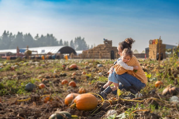 istock Mother and young daughter hug while at a pumpkin patch 1898188694