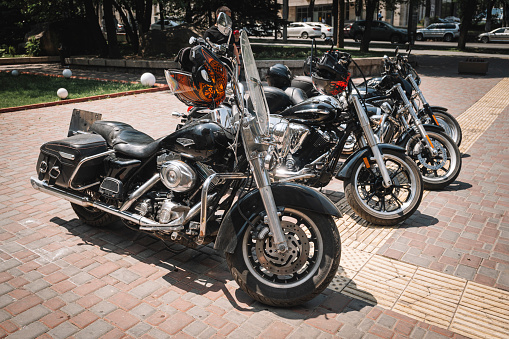 several large American Harley Davidson motorcycles stand in a row in the parking lot, Almaty, Kazakhstan. May 26, 2023