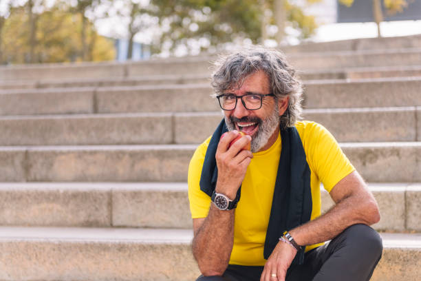 istock happy senior man eating an apple after workout 1898216096