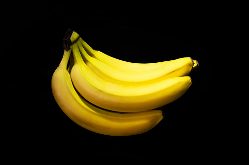 bunch of yellow bananas on a black background