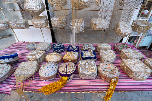 Skullcap, tubereika . A lot of knitted ethnic hats: skullcaps on counter of shop, store in Uzbekistan. Traditional national Uzbek headdress, costume, dress, handicraft. Uzbek fashion style. Tubeteyka
