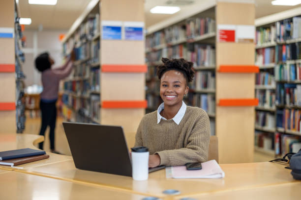 istock African-American Young Student Smiling To The Camera While Using A Laptop 1898246717