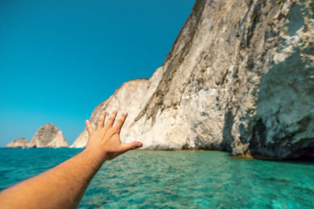 istock A Hand Reaching Out With a Beautiful Seascape And Cliffs In The Background 1898250498