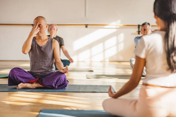 istock Mature People Of Different Cultures Sitting Practicing Yoga 1898253803