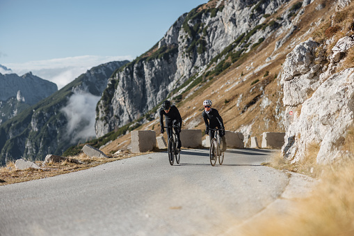 Confident professional cyclists on their road bikes, surrounded by the rugged beauty of nature.