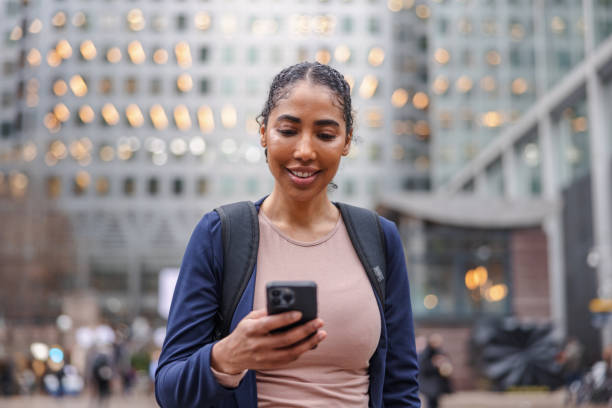 istock Dark-Skinned Business Woman Holding Her Cellphone And Reading Something On It While Walking Outside At A Business District 1898256226