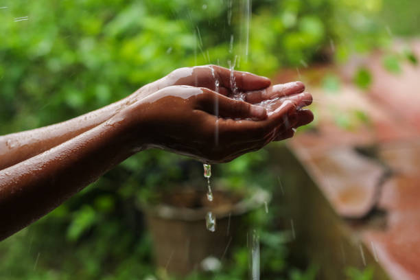 istock hands with splashes of falling rain 1898261894