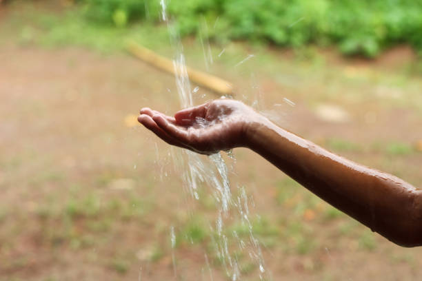 istock hands with splashes of falling rain 1898262478