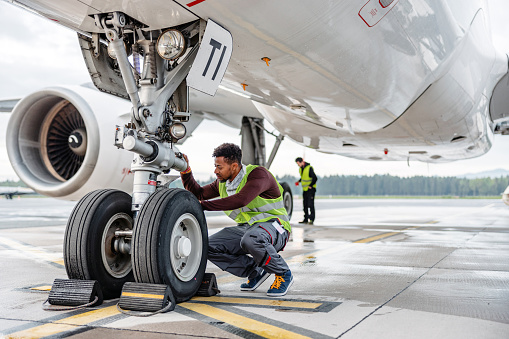 An aircraft engineer repairing and maintaining jet airplane.