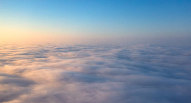 Dawn's Awakening: Illuminating the Sky Beyond the Cloud Veil Celestial Canvas: Capturing Sunset's Beauty Above the Cloudscape stratosphere airplane cloudscape mountain stock pictures, royalty-free photos & images