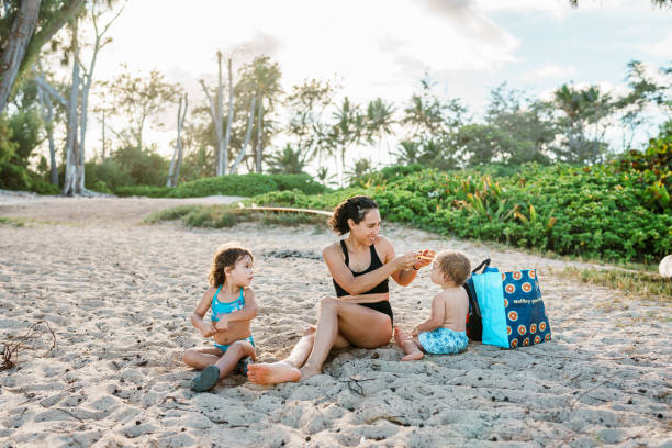 istock Mother plays with her young children at the beach 1898331018