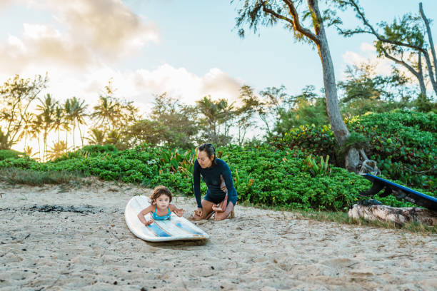istock Toddler lays on surfboard while learning how to surf 1898331415