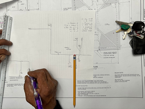 Construction worker writing up a blueprint for a floor plan