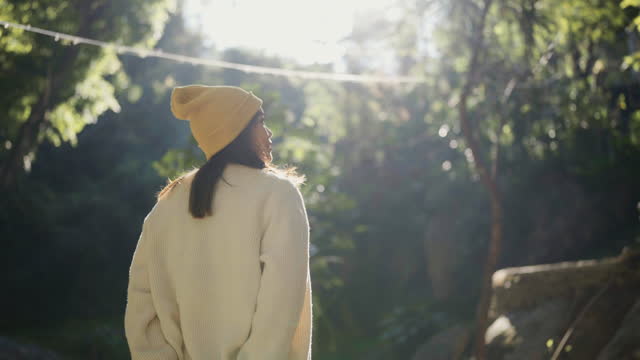 Rear view of Asian woman in warm clothes walking in the forest Feel refreshed in Chiang Mai, Thailand