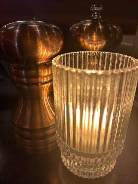 istock Illuminated Candlelight Votive Beside Brass Salt And Pepper Shakers 1898845073
