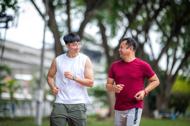 istock Inspired Fitness: Trainer Motivating Mature Man's Park Workout Session 1898862965