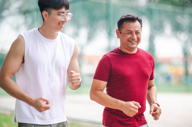 istock Wellness Support: Trainer Encouraging Mature Man's Outdoor Workout at Park 1898863471