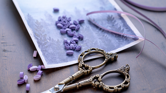 Crafting Time: Vintage Scissor with Purple Quilled Rolls on Wooden Table