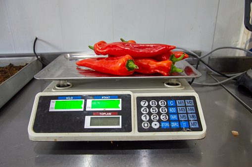 weighing red pepper at work with an electronic scale