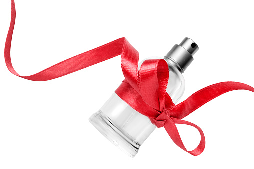 Perfume spray bottle tied red satin bow isolated on white background
