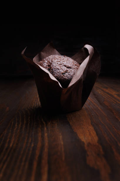 istock Chocolate cupcake on a dark background. Muffin with chocolate chips on a wooden surface. 1899041714
