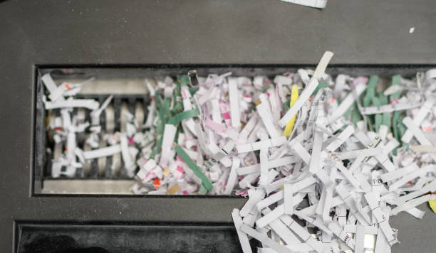istock Frayed company documents falling from the blade of a paper shredder 1899081378