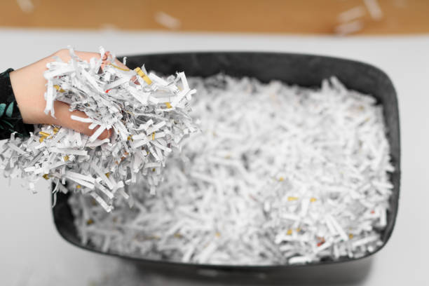 Throw away waste paper in a bag, documents shredded in a shredder closeup