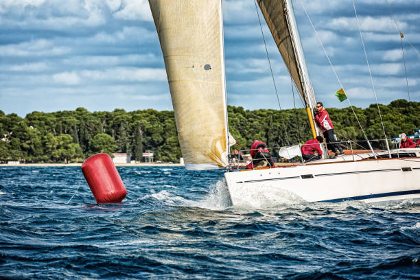 istock Sailing crew on sailboat on regatta turning on buoy 1899088091
