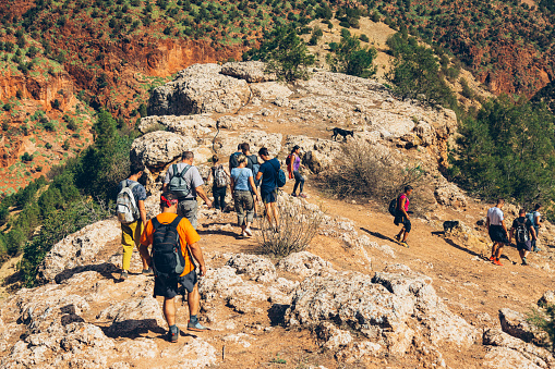 Group of tourists on hiking on trails near Ouzoud town, Atlas, Morocco. All Model released.