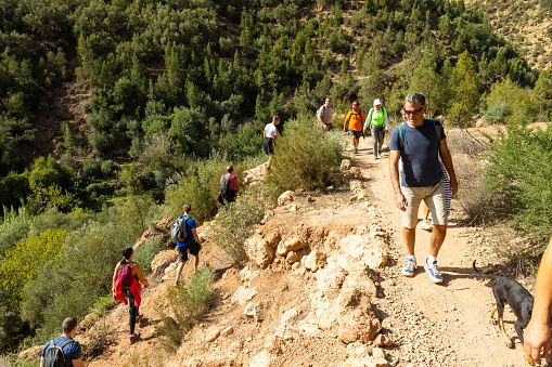 Group of tourists on hiking on trails near Ouzoud town, Atlas, Morocco. All Model released.