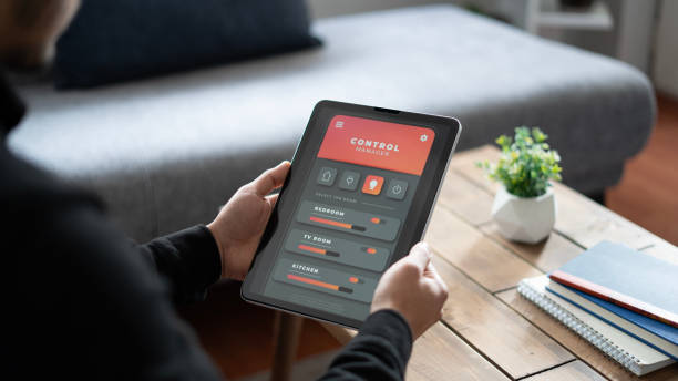istock Close-up Man controls the lighting of a smart house with a tablet 1899213450