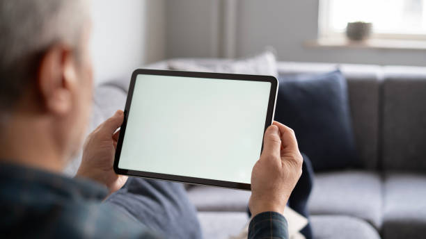istock Adult man using digital tablet while lying at home , mock-up screen 1899216052
