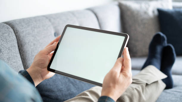 istock Adult man using digital tablet while lying at home , mock-up screen 1899218626
