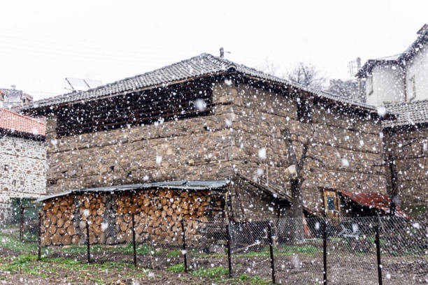 Old village house and falling snow
