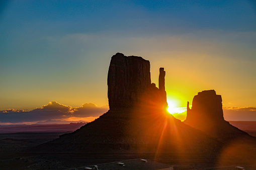 Sunrise behind Monument Valley rock formations